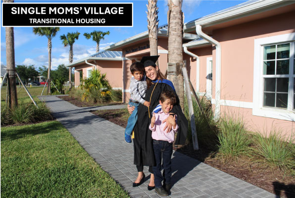 Single-mom-in-graduation-gown-with-sons-in-front-of-triplex